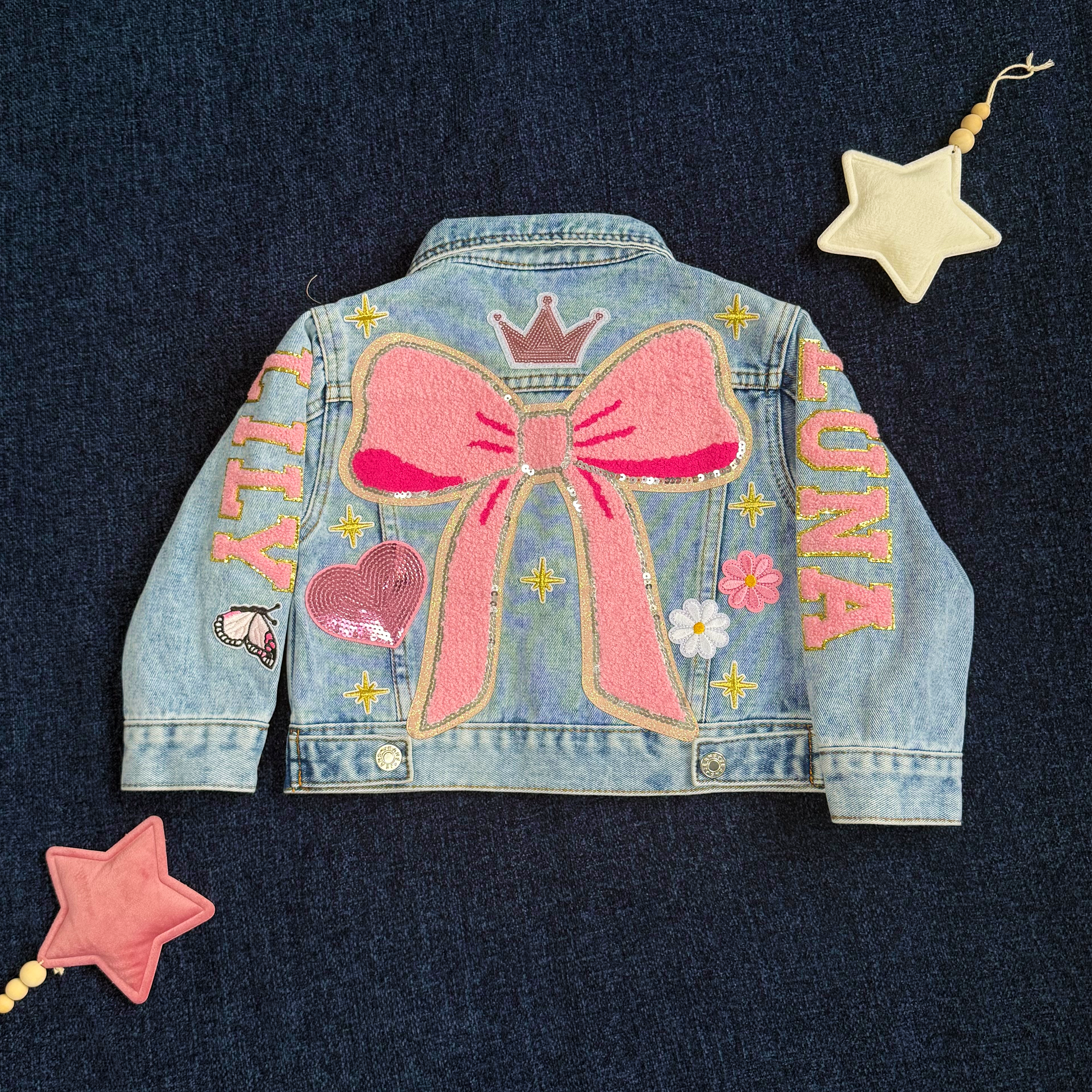 Denim jacket with pink bow and 'LUNA' text on a dark blue background